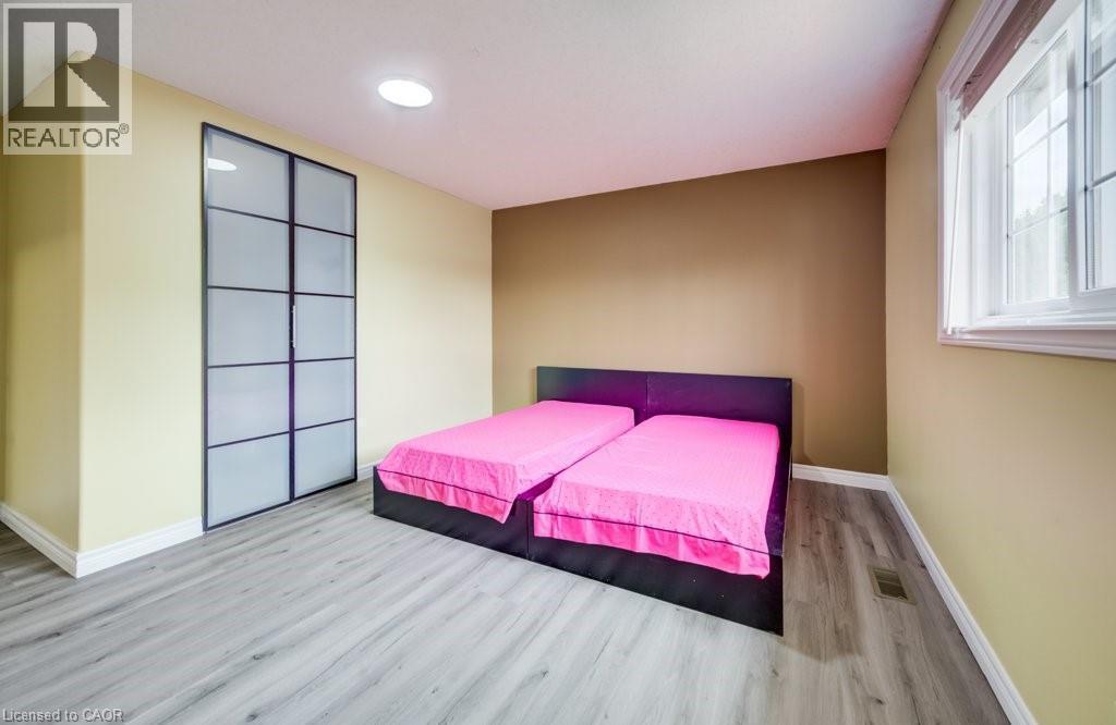 Bedroom featuring wood-finish flooring, a contemporary window, and a built-in closet with frosted glass panel doors - 123 Forest Edge Trail, Kitchener, ON - Indoor Photo Showing Bedroom