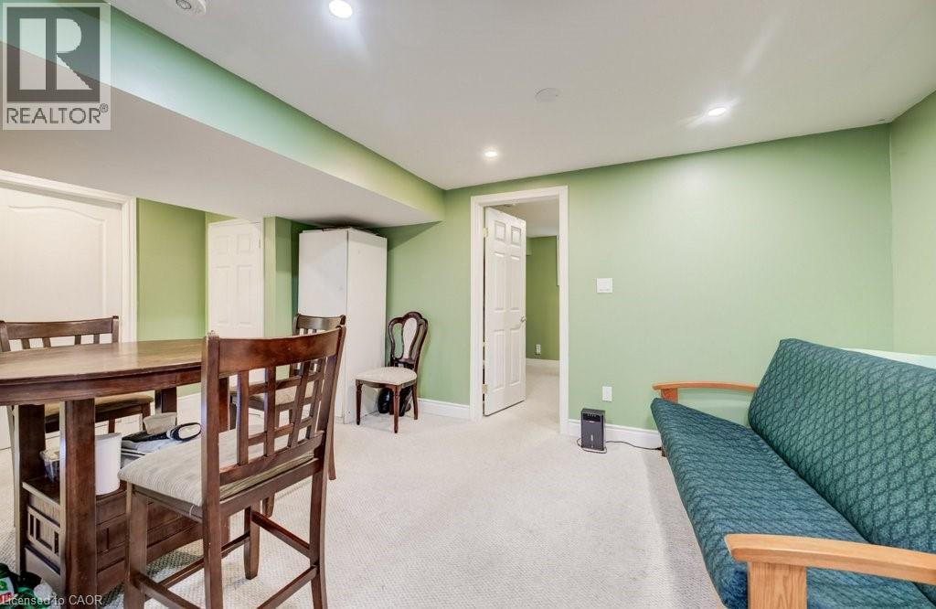 Carpeted recreation area featuring recessed lighting, a dropped ceiling with exposed beams, and a doorway leading to an additional space - 123 Forest Edge Trail, Kitchener, ON - Indoor