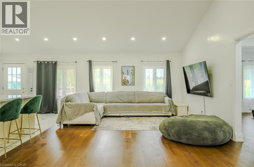 Bright interior with rich wood-finish flooring, recessed ceiling lighting, and multiple windows - 107 6Th Line Line, Caledonia, ON - Indoor Photo Showing Living Room