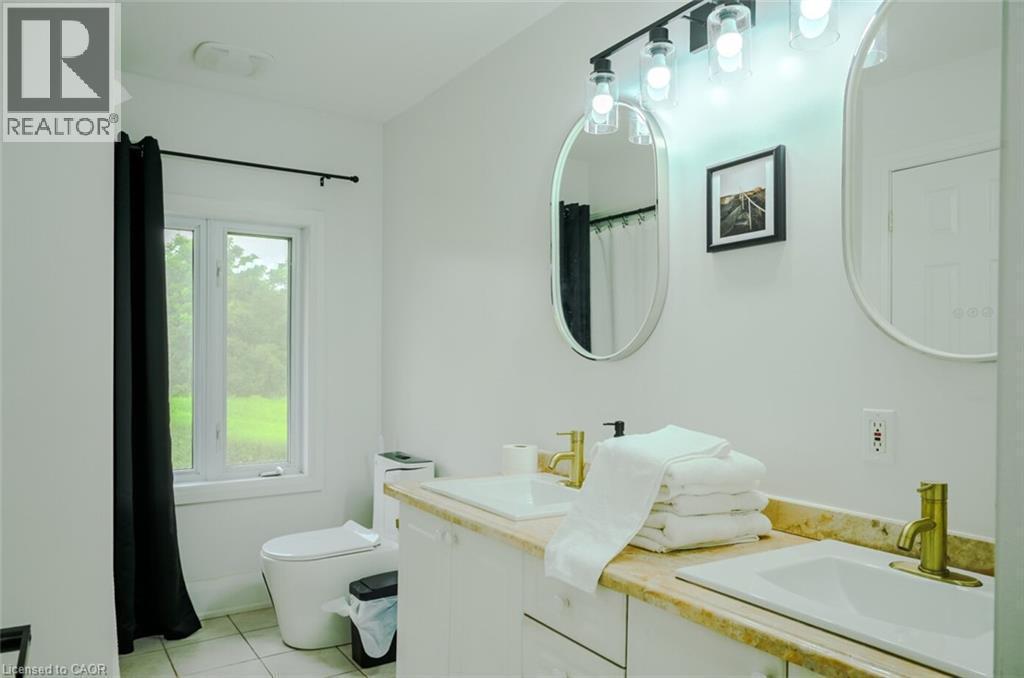 Dual vanity with undermount sinks, gold-finish faucets, and an expansive countertop - 107 6Th Line Line, Caledonia, ON - Indoor Photo Showing Bathroom