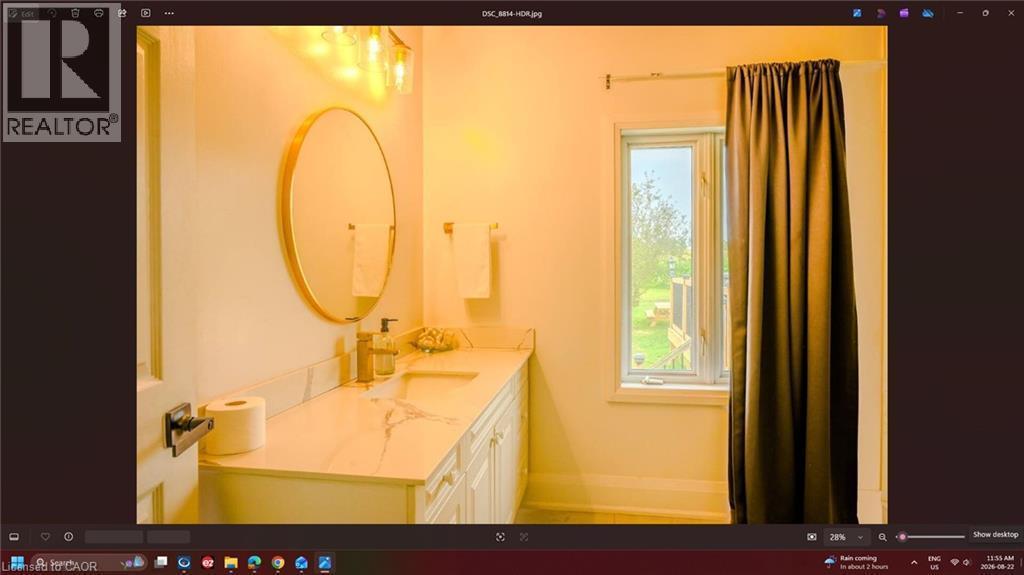 White vanity with integrated sink, stone-finish countertop, and wall-mounted lighting - 107 6Th Line Line, Caledonia, ON - Indoor Photo Showing Bathroom