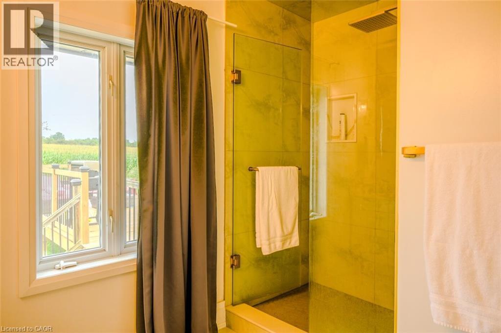 Glass-enclosed shower with a rainfall showerhead, recessed niche, and tiled walls - 107 6Th Line Line, Caledonia, ON - Indoor