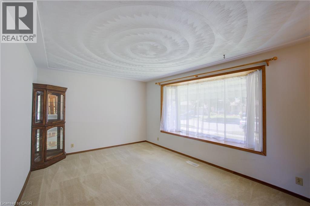 Bay window with wood trim, wall-to-wall carpeting, and a textured ceiling - 52 Queenston Crescent, Kitchener, ON - Indoor Photo Showing Other Room