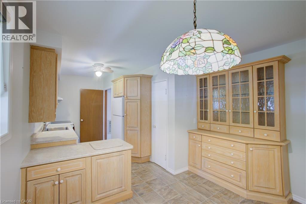 Kitchen featuring wood cabinetry, laminate countertops, a ceiling fan, and tiled flooring - 52 Queenston Crescent, Kitchener, ON - Indoor