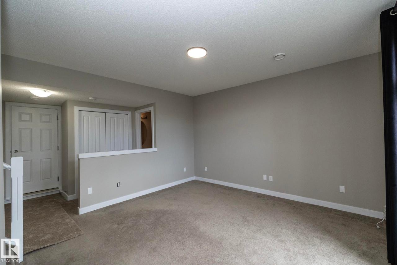 Neutral tone wall paint with white trim, recessed lighting, and carpeted flooring - 117 Callaghan Drive Sw, Edmonton, AB - Indoor Photo Showing Other Room