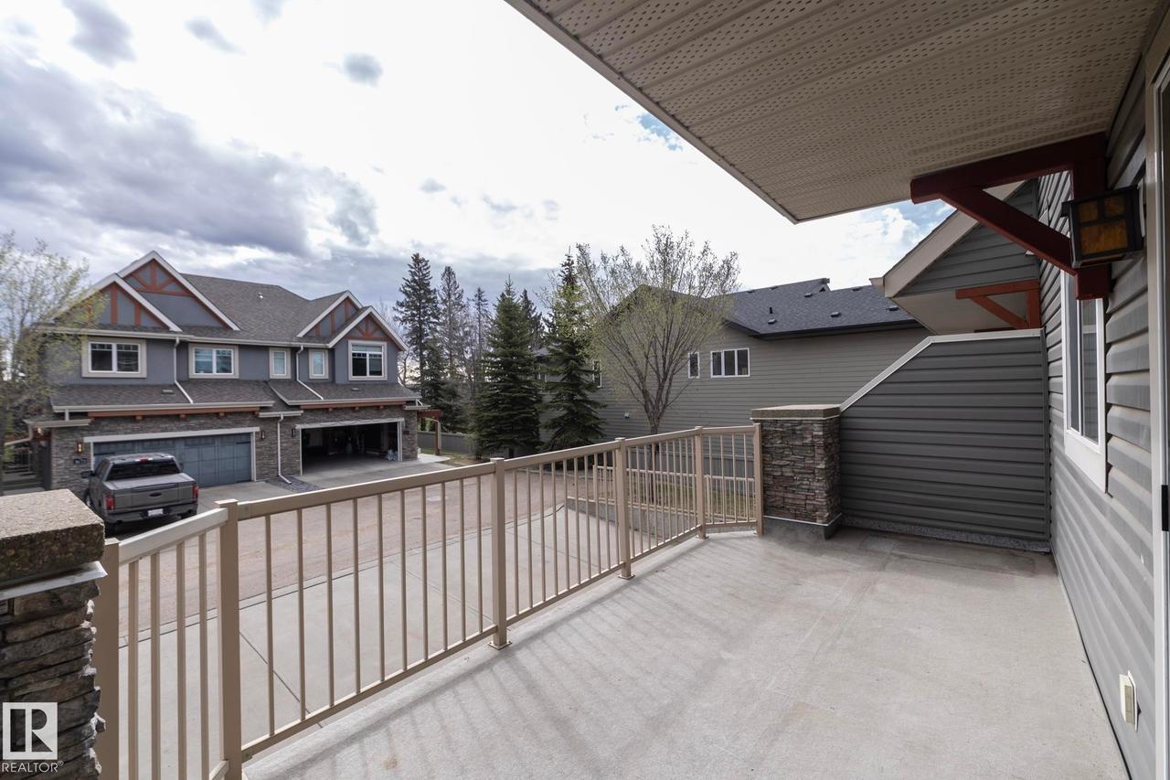 Expansive concrete balcony with metal railings and stone-clad pillars - 117 Callaghan Drive Sw, Edmonton, AB - Outdoor With Exterior