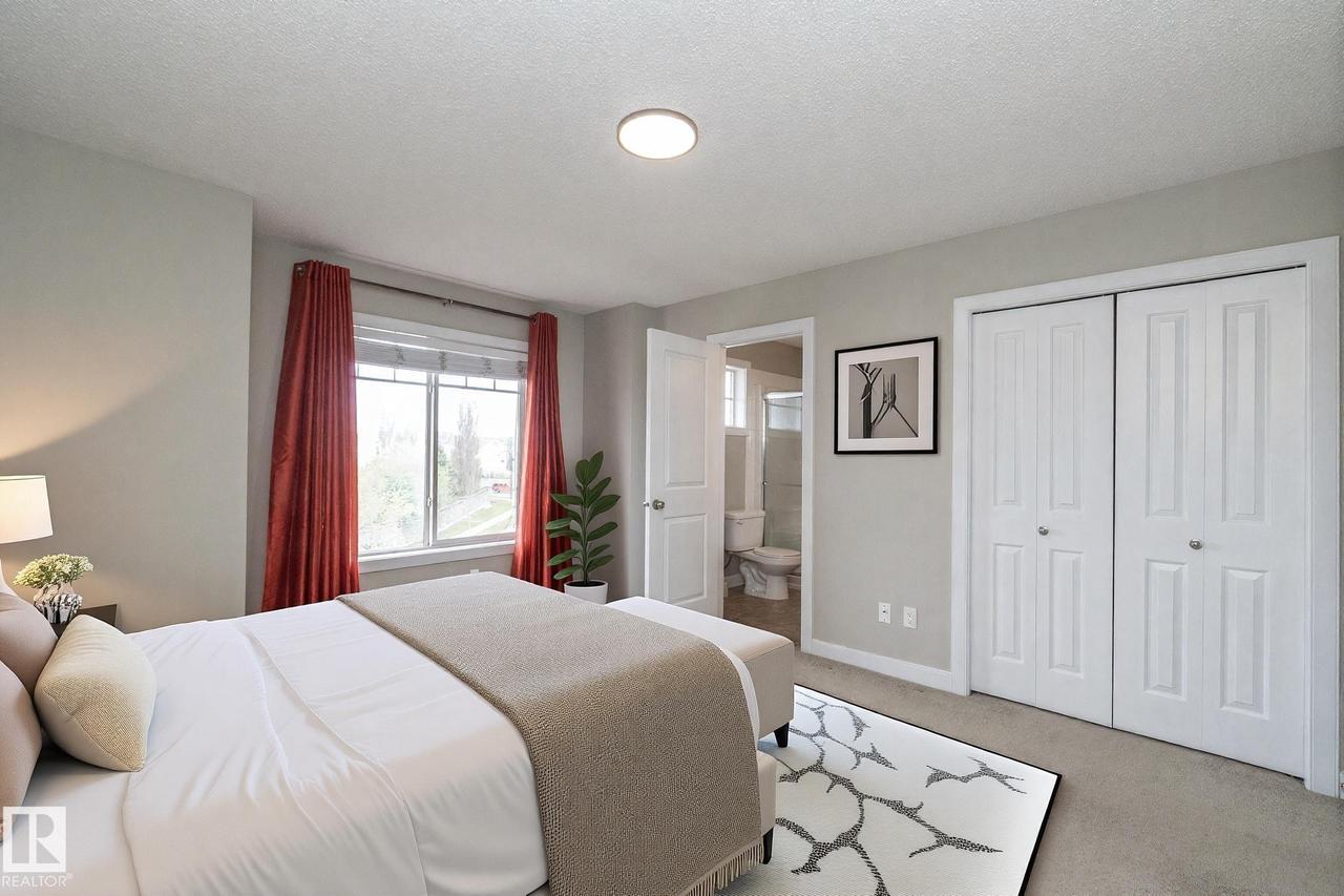 Carpeted room featuring a double window, two white bi-fold closet doors, and light gray painted walls - 117 Callaghan Drive Sw, Edmonton, AB - Indoor Photo Showing Bedroom