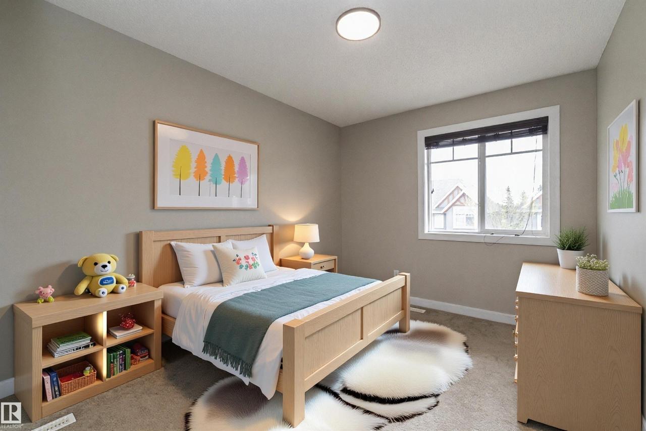 Neutral-toned bedroom featuring a light wood-finish bed frame, plush carpet flooring, a large window with white trim, and a ceiling-mounted light fixture - 117 Callaghan Drive Sw, Edmonton, AB - Indoor Photo Showing Bedroom