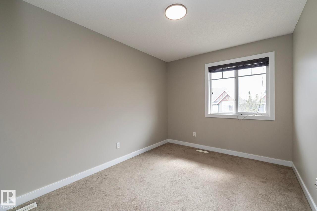 Carpeted room with a double-pane window, white trim, and a flush-mount ceiling light - 117 Callaghan Drive Sw, Edmonton, AB - Indoor Photo Showing Other Room