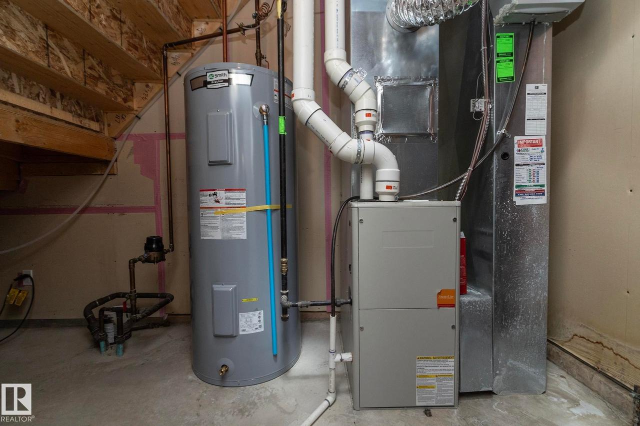 Mechanical room featuring a water heater, furnace, and exposed ductwork - 117 Callaghan Drive Sw, Edmonton, AB - Indoor Photo Showing Basement