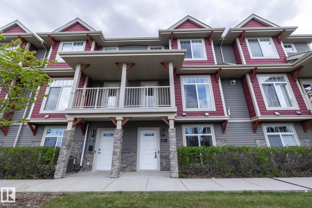Townhome exterior featuring gray horizontal siding and red shake accents - 117 Callaghan Drive Sw, Edmonton, AB - Outdoor With Facade