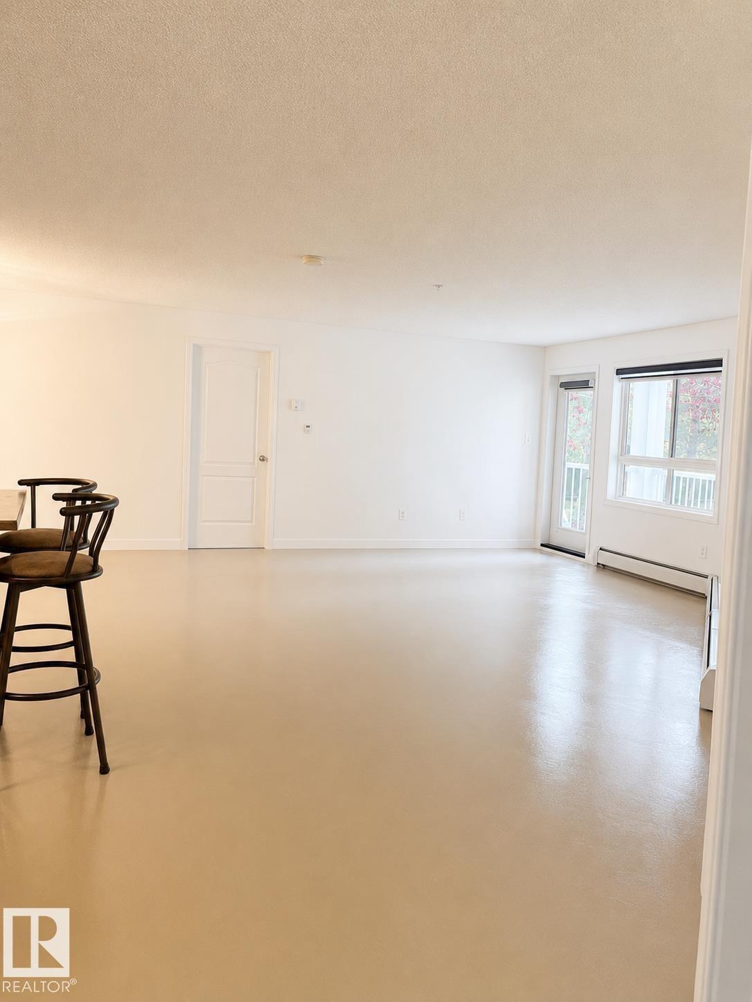 Expansive living area with neutral color palette and light-toned flooring - #115 5340 199 St Nw, Edmonton, AB - Indoor Photo Showing Other Room