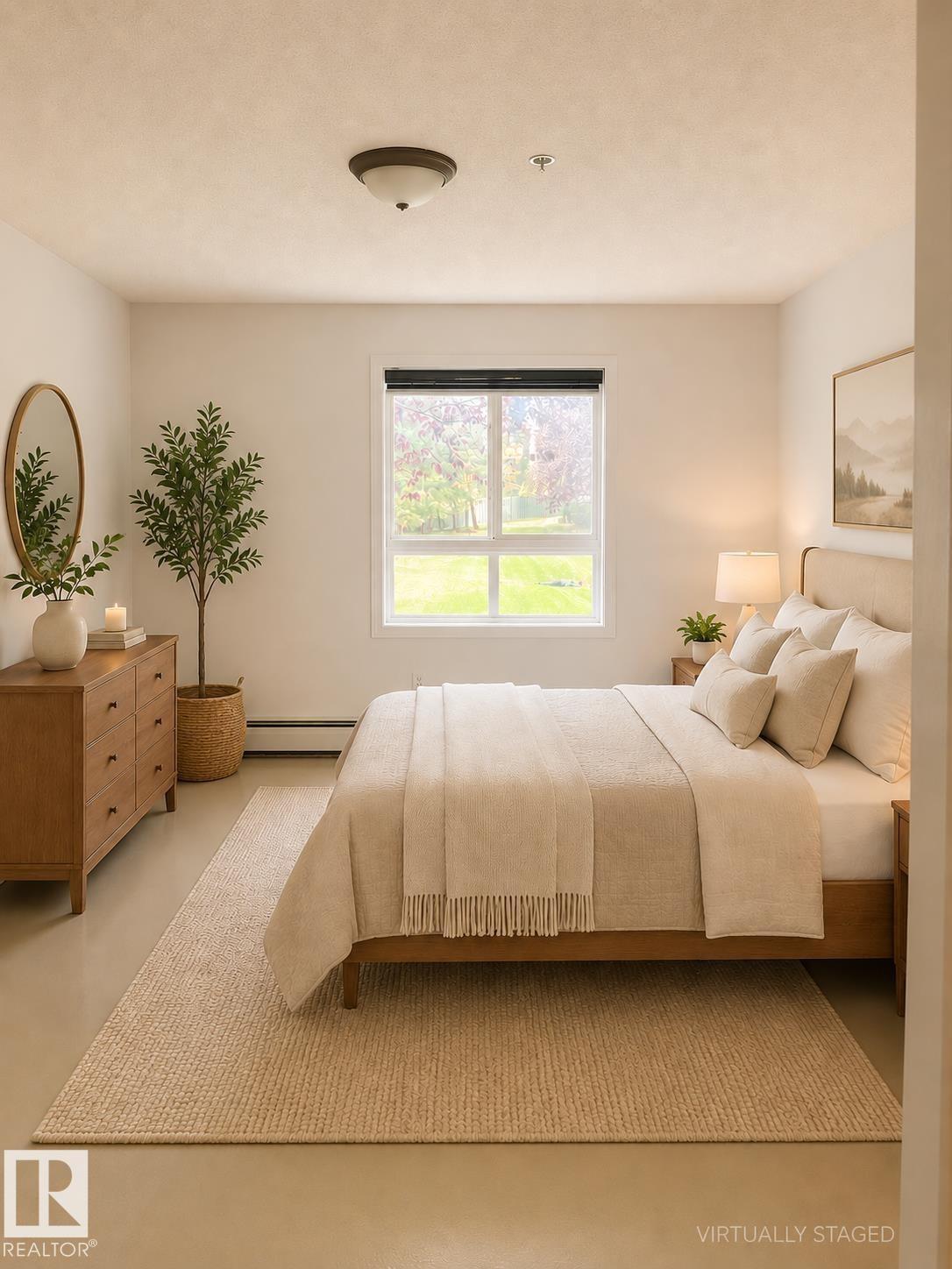 Bright bedroom featuring a large window, neutral wall tones, and overhead lighting - #115 5340 199 St Nw, Edmonton, AB - Indoor Photo Showing Bedroom