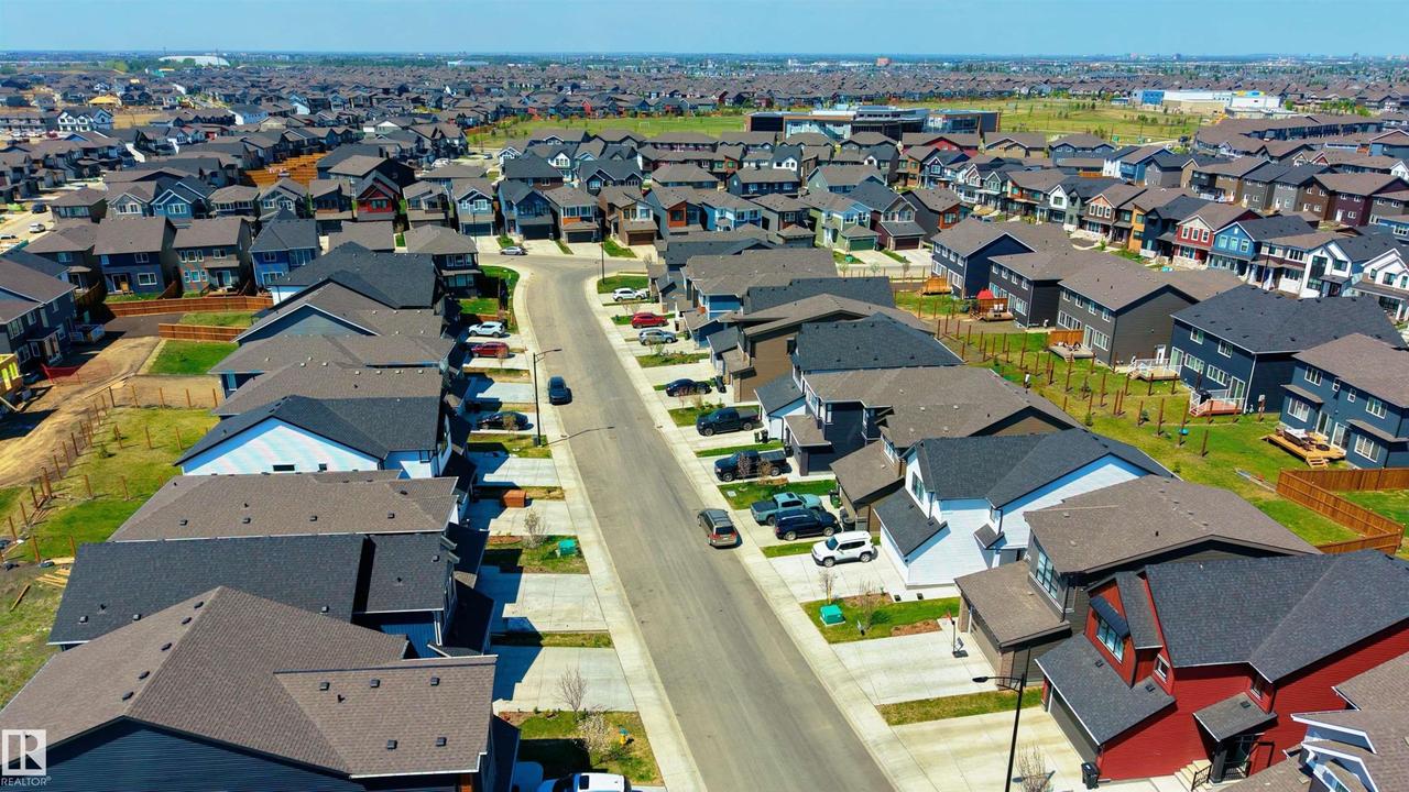Residential street with multiple homes featuring varied architectural styles and rooflines - 2120 Muckleplum Crescent Sw, Edmonton, AB - Outdoor With View