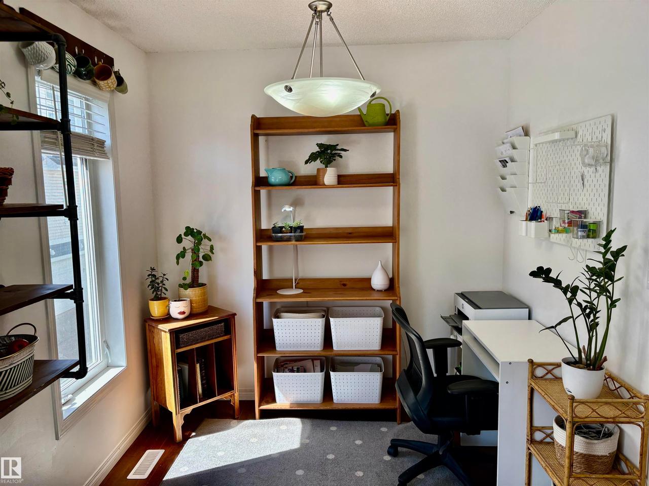 Bright room with white walls, wood-finish flooring, and a window with blinds - #184 1804 70 St Sw, Edmonton, AB - Indoor