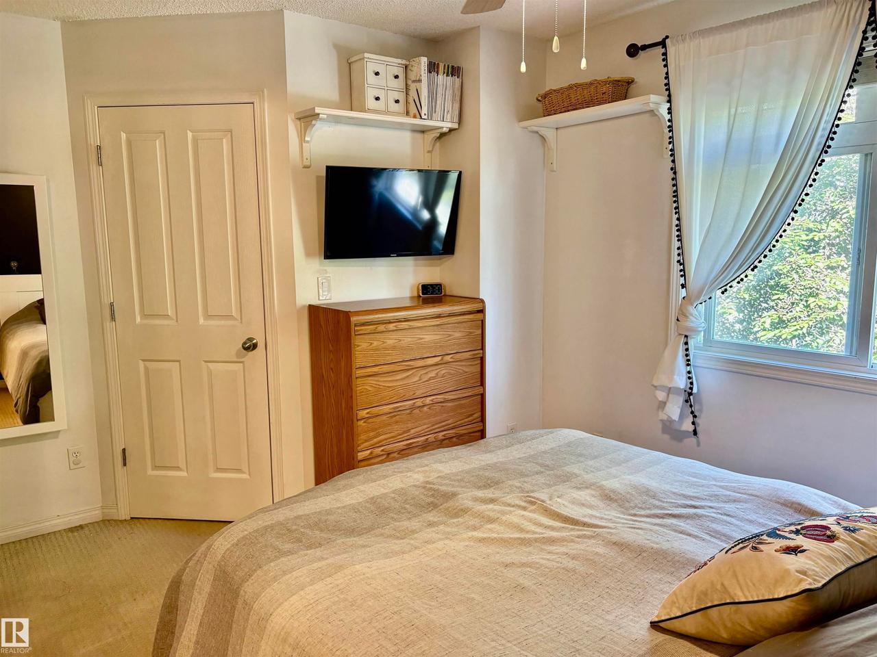 Bright bedroom space featuring a window with exterior views - #184 1804 70 St Sw, Edmonton, AB - Indoor Photo Showing Bedroom