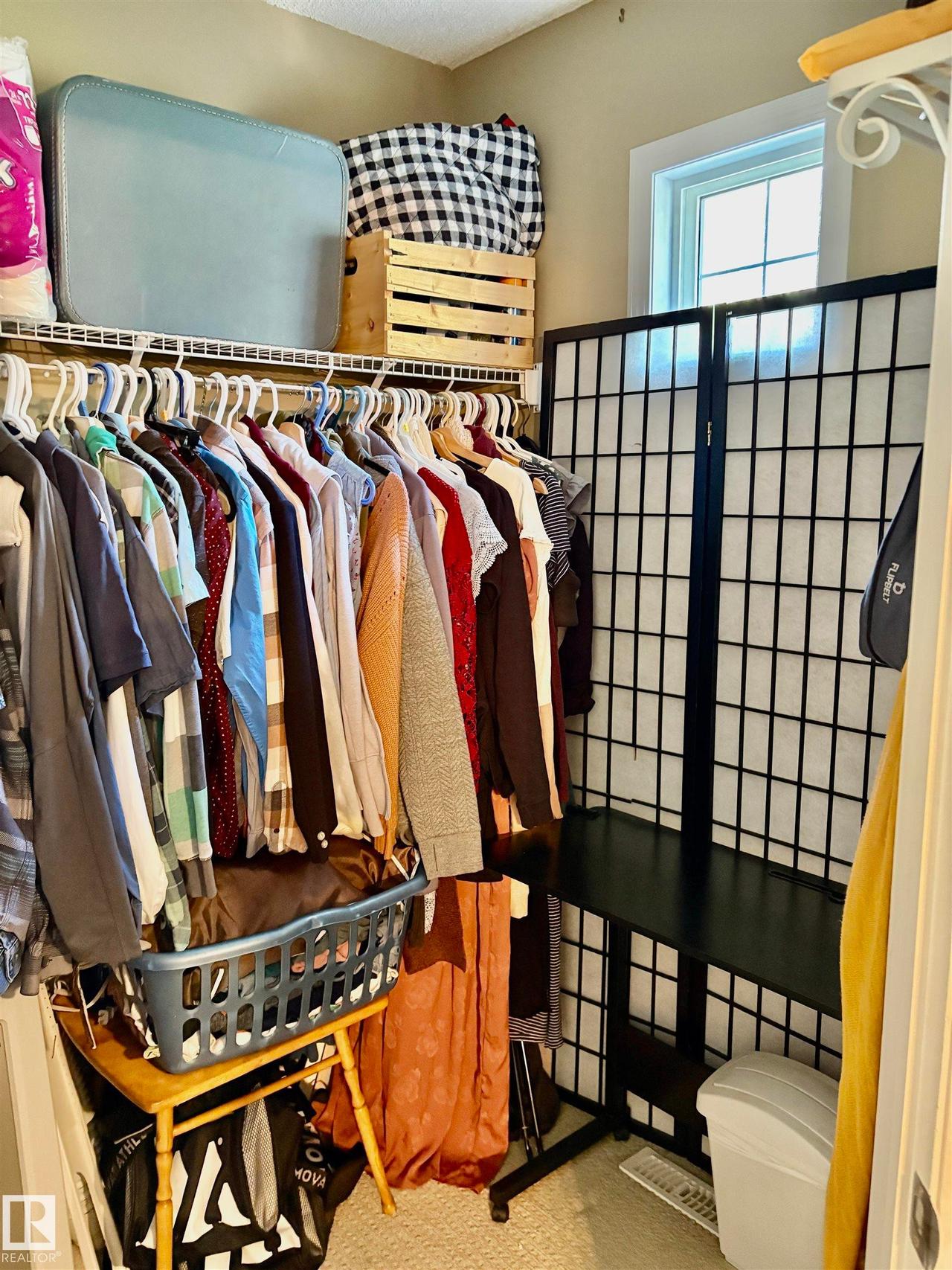Closet space featuring wire shelving, a window providing natural light, and neutral-toned walls - #184 1804 70 St Sw, Edmonton, AB - Indoor