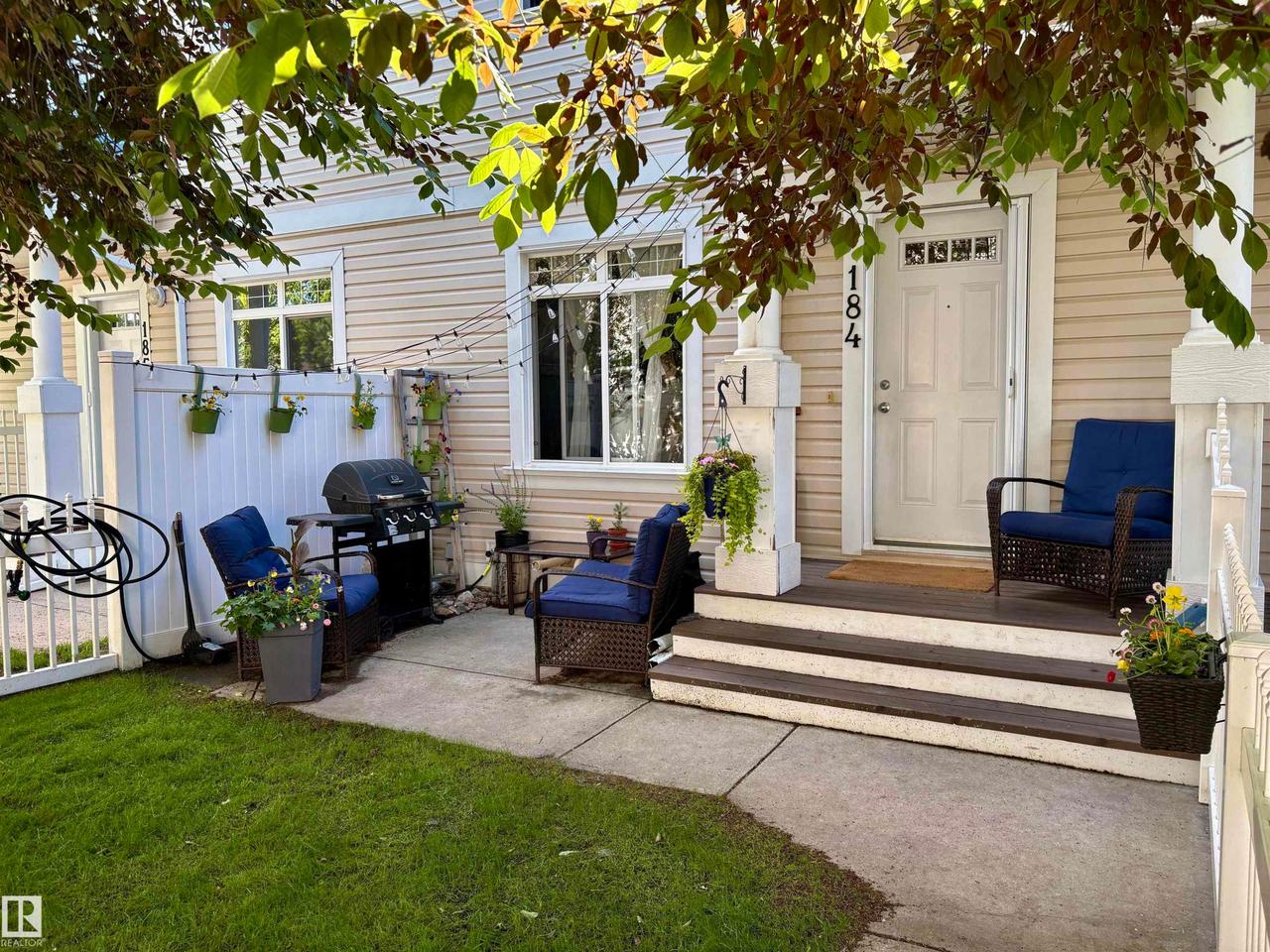 Front facade with horizontal siding and a white entry door featuring decorative glass - #184 1804 70 St Sw, Edmonton, AB - Outdoor With Deck Patio Veranda