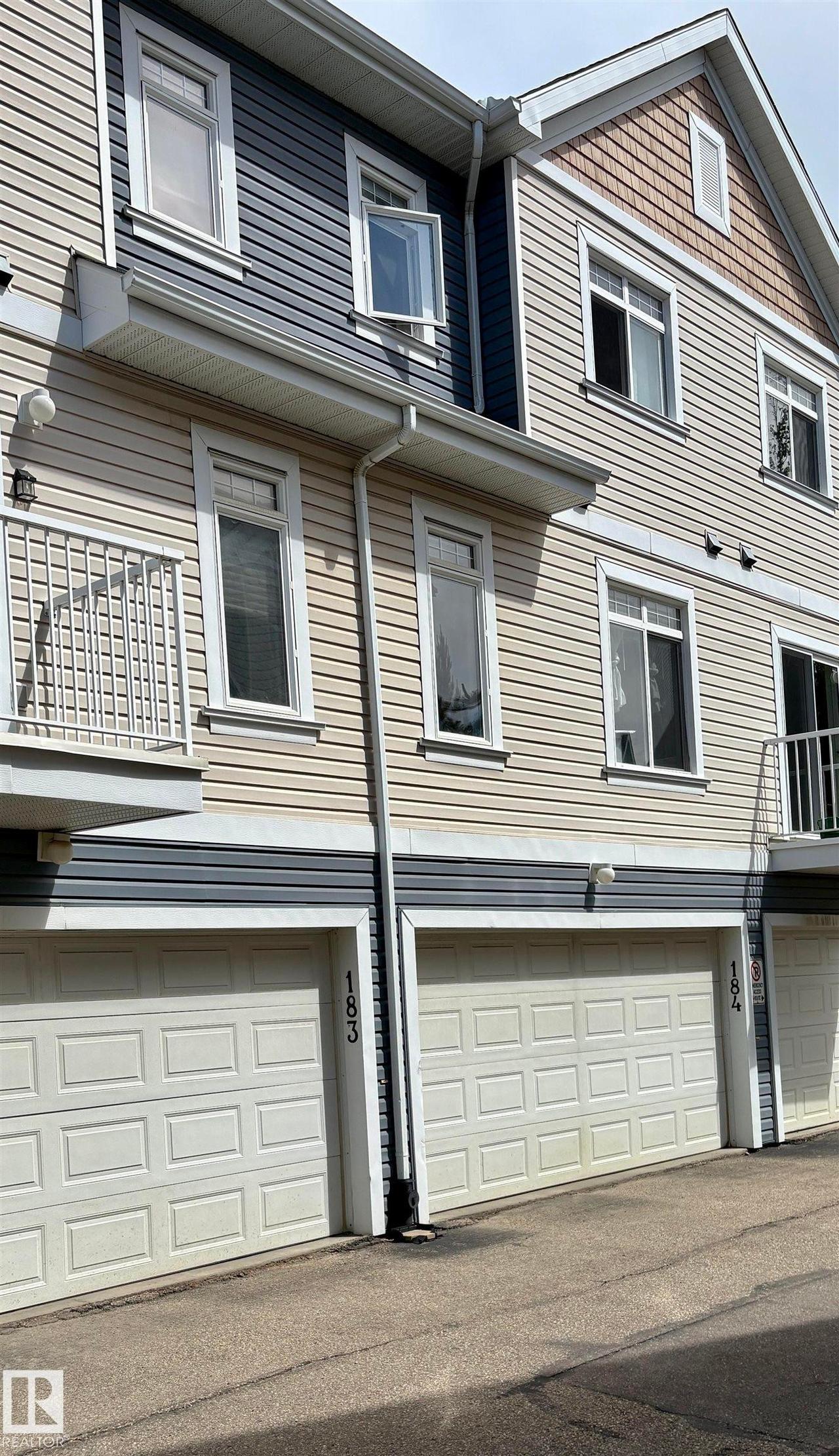 Multi-level townhouse exterior featuring horizontal siding and decorative shingles - #184 1804 70 St Sw, Edmonton, AB - Outdoor