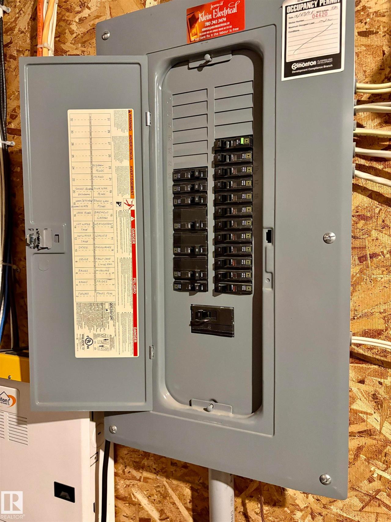 Electrical panel featuring a gray metal enclosure, multiple circuit breakers, an interior door with a circuit directory, and visible wiring - #184 1804 70 St Sw, Edmonton, AB - Indoor Photo Showing Other Room