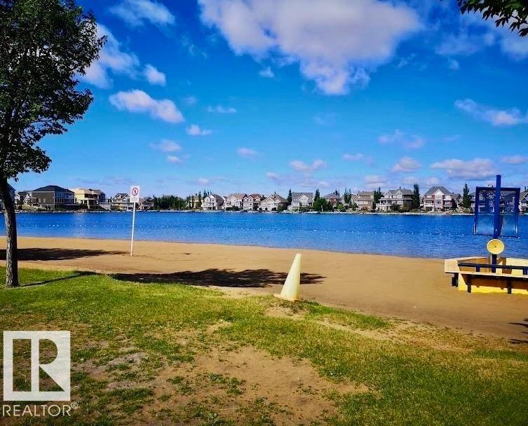 Lakeside setting with a sandy beach and green space - #184 1804 70 St Sw, Edmonton, AB - Outdoor With Body Of Water With View