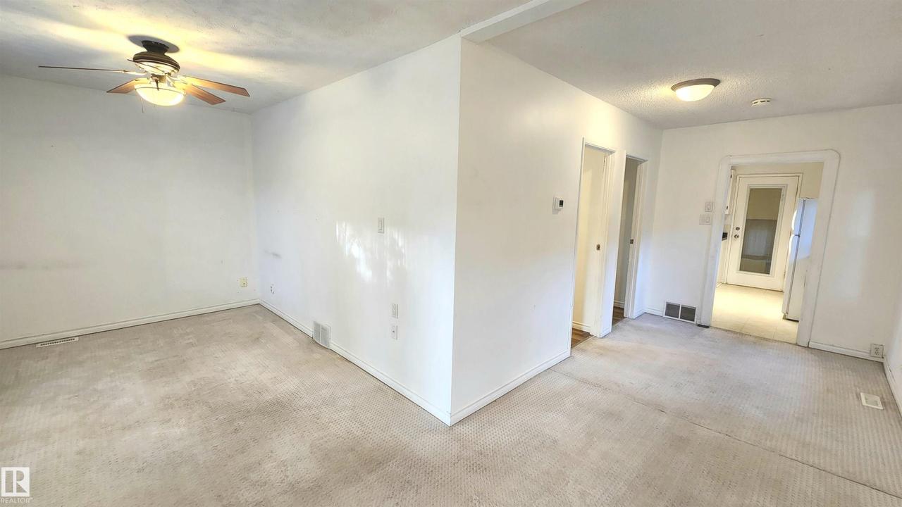 Expansive interior space featuring carpet flooring and white painted walls - 9359 92 Street Nw, Edmonton, AB - Indoor Photo Showing Other Room
