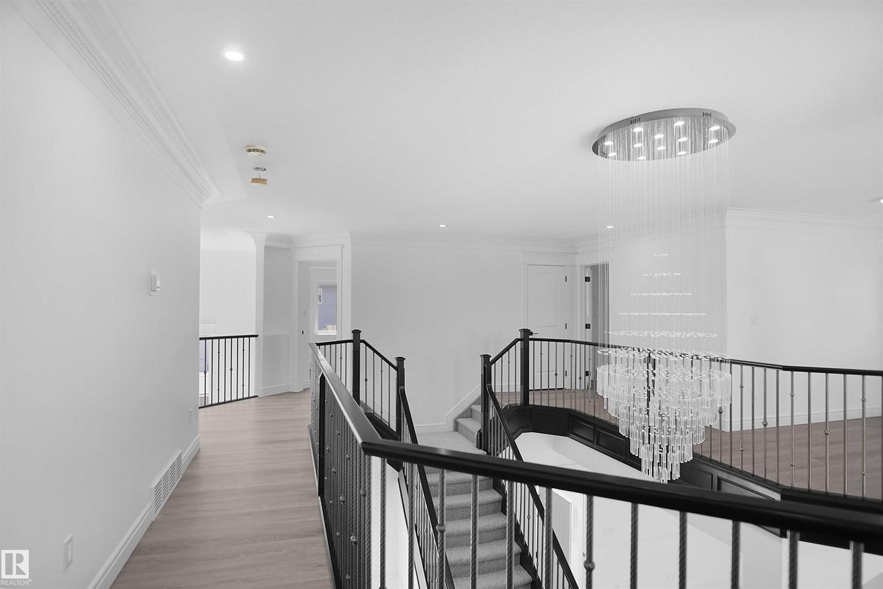 Grand staircase with dark wood handrails and wrought iron balusters - 6823 18 Avenue Sw, Edmonton, AB - Indoor Photo Showing Other Room
