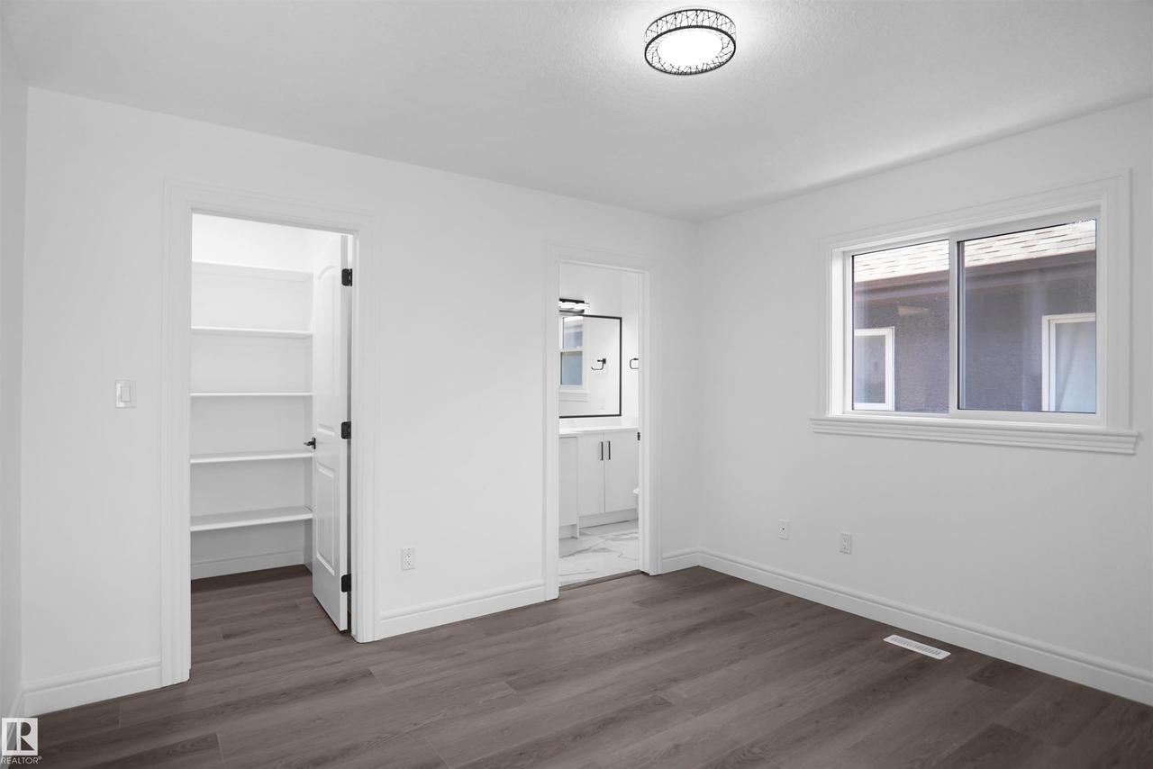 Wood-finish flooring with white walls and trim - 6823 18 Avenue Sw, Edmonton, AB - Indoor Photo Showing Other Room