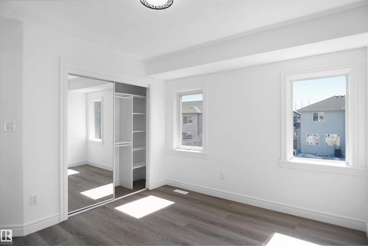 Recessed ceiling, wood-finish flooring, white trim, mirrored sliding closet doors, built-in closet shelving - 6823 18 Avenue Sw, Edmonton, AB - Indoor Photo Showing Other Room