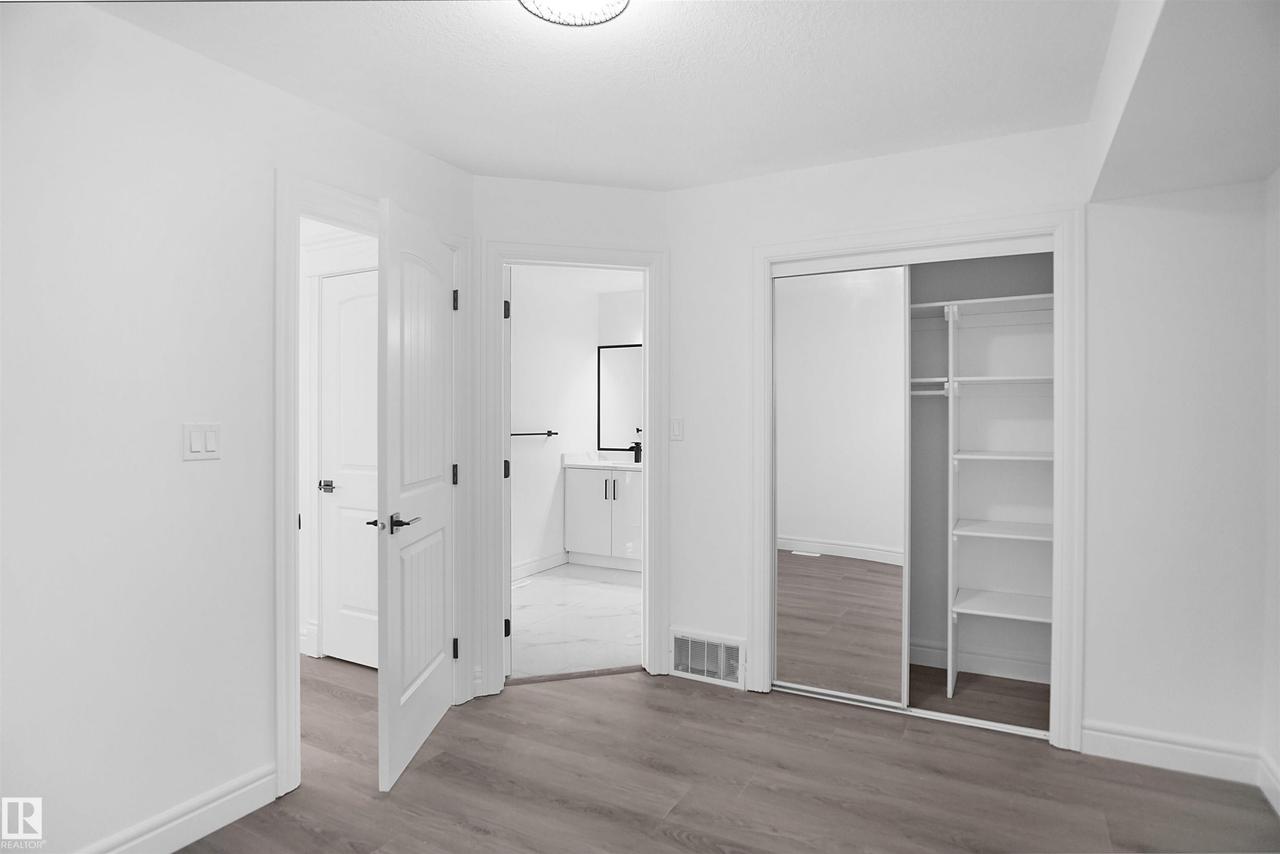 Wood-finish flooring, white walls, and a contemporary ceiling light fixture - 6823 18 Avenue Sw, Edmonton, AB - Indoor Photo Showing Other Room