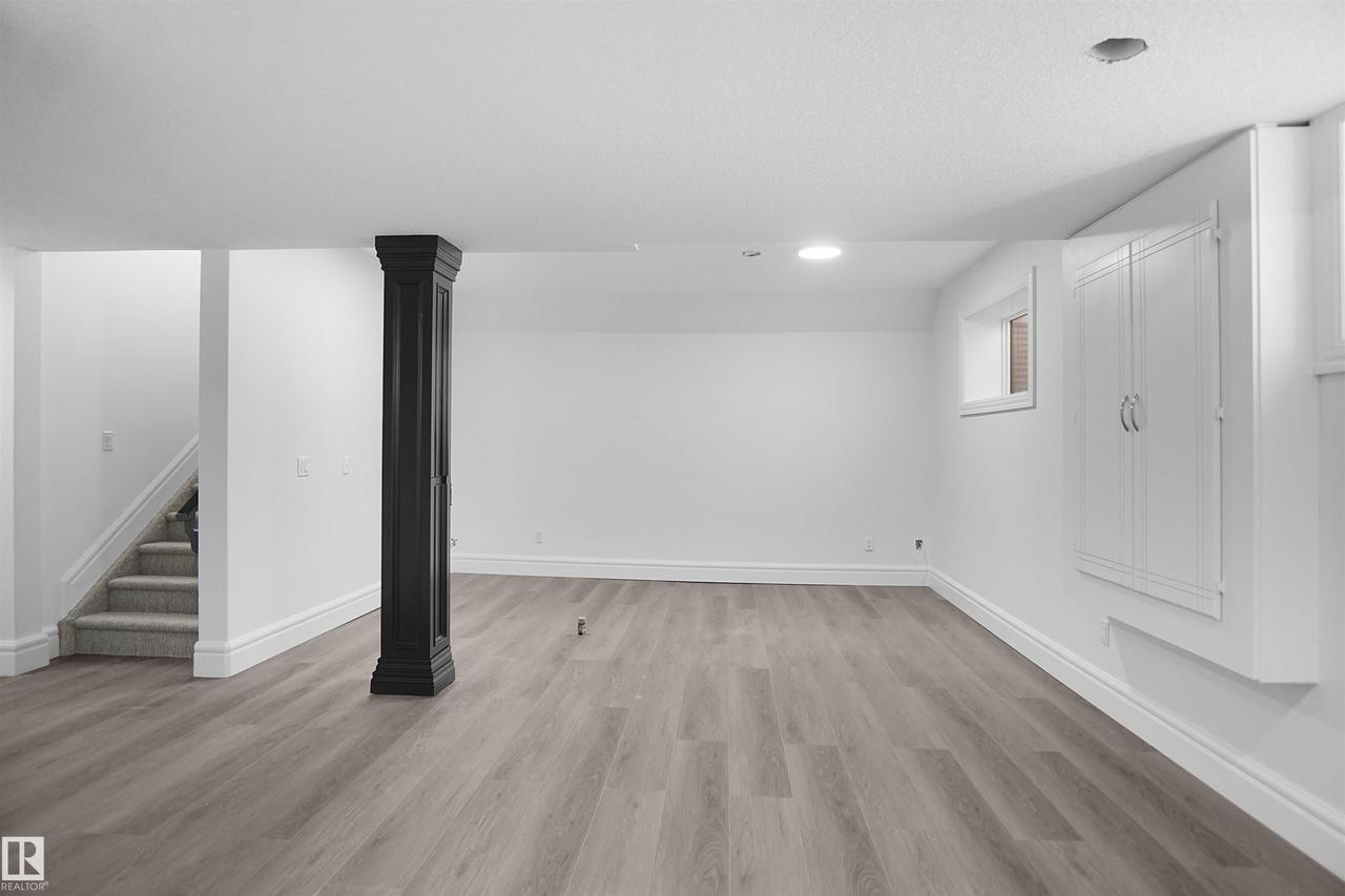 Spacious room with wood-finish flooring, recessed lighting, and a built-in storage cabinet - 6823 18 Avenue Sw, Edmonton, AB - Indoor Photo Showing Other Room