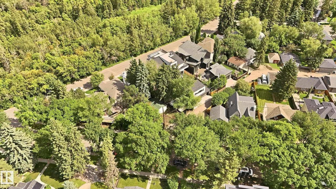Residential neighborhood featuring mature trees and a dense tree line bordering the properties - 14631 Summit Drive Nw, Edmonton, AB - Outdoor With View
