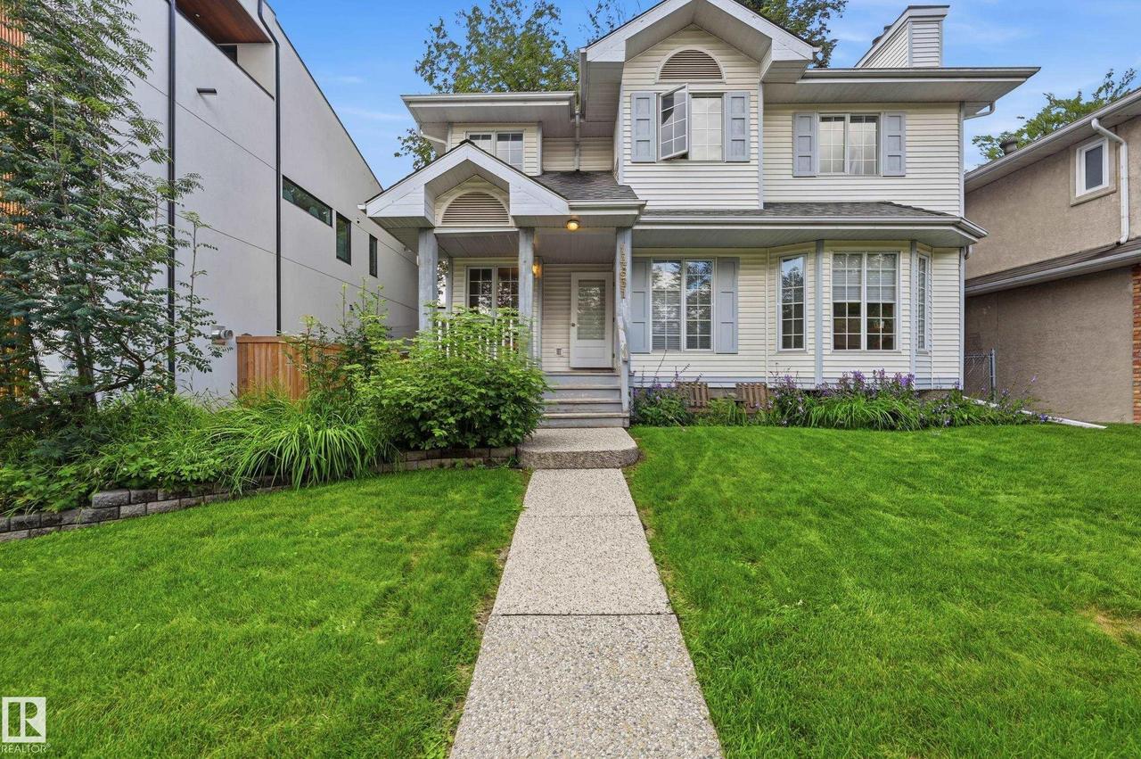 Exterior featuring light-colored siding, multiple gabled rooflines, a covered front porch, and a bay window with decorative shutters - 14631 Summit Drive Nw, Edmonton, AB - Outdoor With Facade
