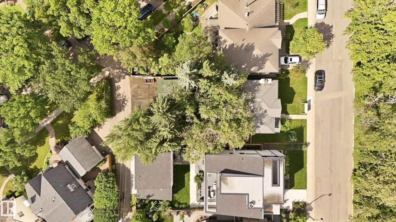 Modern architectural design with expansive glazing, a glass-paneled balcony, a tiered concrete staircase, and integrated outdoor lighting - 14631 Summit Drive Nw, Edmonton, AB - Outdoor